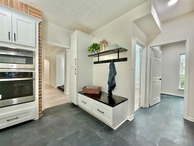 19 Pebble Hollow Ct, The Woodlands, TX 77381 - mudroom with baseboards and a textured ceiling