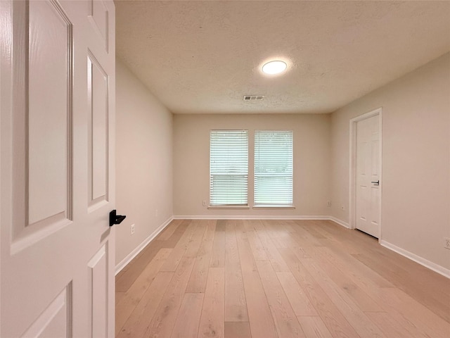 19 Pebble Hollow Ct, The Woodlands, TX 77381 - spare room with a textured ceiling and light wood finished floors