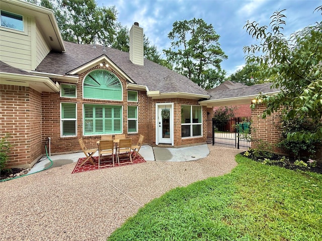 19 Pebble Hollow Ct, The Woodlands, TX 77381 - back of property featuring a patio, brick siding, a chimney, and a shingled roof