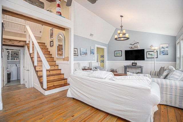 16615 Mansvelt Rd, Jamaica Beach, TX 77554 - living room featuring washer / dryer, wainscoting, lofted ceiling, a chandelier, and stairway