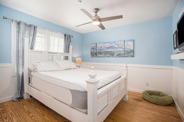 16615 Mansvelt Rd, Jamaica Beach, TX 77554 - bedroom featuring wainscoting, wood finished floors, and ceiling fan