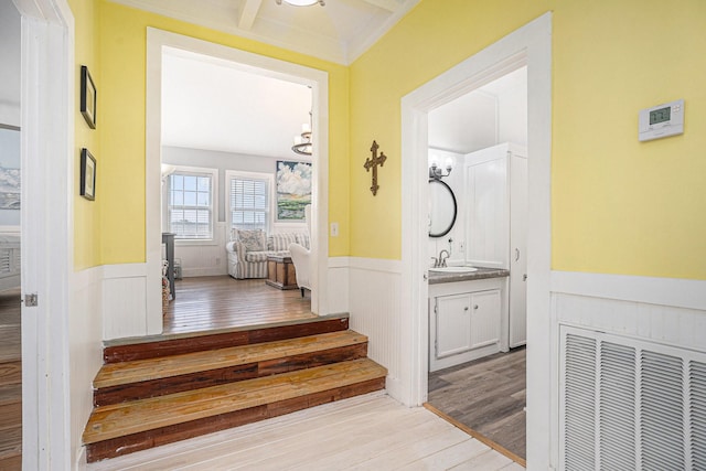 16615 Mansvelt Rd, Jamaica Beach, TX 77554 - corridor featuring wainscoting, wood finished floors, stairway, and a decorative wall