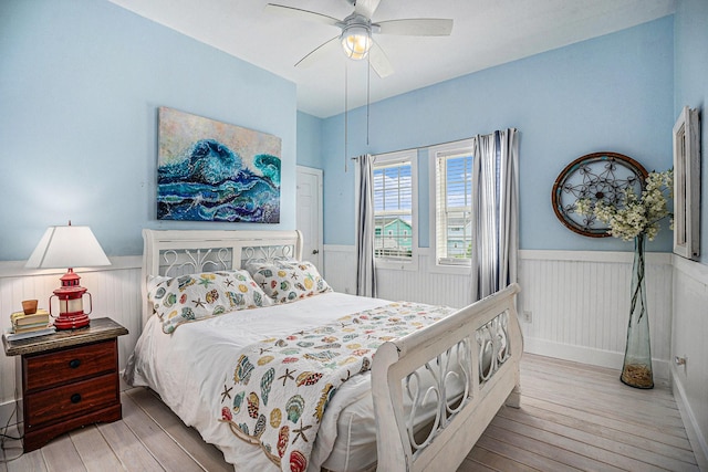 16615 Mansvelt Rd, Jamaica Beach, TX 77554 - bedroom with wood-type flooring, wainscoting, and a ceiling fan