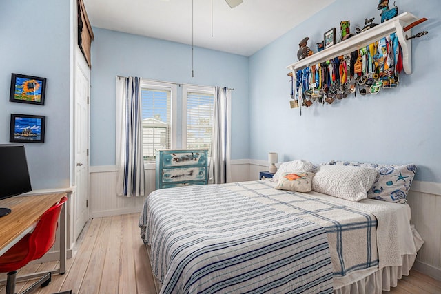 16615 Mansvelt Rd, Jamaica Beach, TX 77554 - bedroom with light wood-style flooring, a wainscoted wall, and ceiling fan