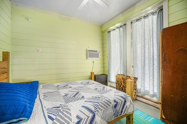 16615 Mansvelt Rd, Jamaica Beach, TX 77554 - bedroom with a wall mounted AC, wooden walls, finished concrete flooring, and a ceiling fan