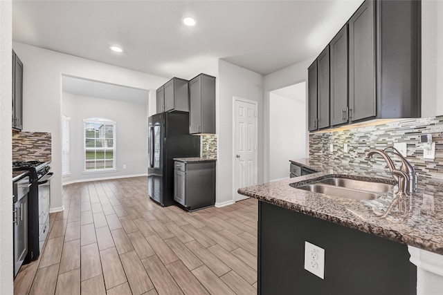 11346 Cascading Stream Way, Houston, TX 77044 - kitchen featuring gas range, freestanding refrigerator, backsplash, dark stone counters, and recessed lighting