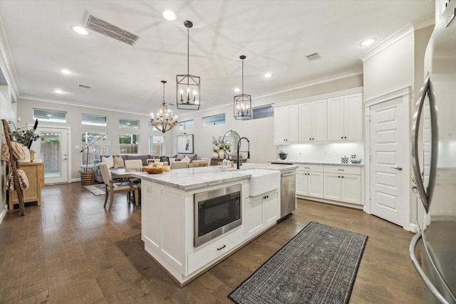 5240 Larkin St, Houston, TX 77007 - kitchen featuring stainless steel appliances, ornamental molding, recessed lighting, a chandelier, and light stone counters