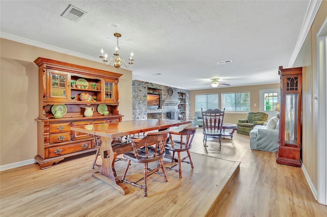 16426 Cavendish Dr, Houston, TX 77059 - dining room with light wood-type flooring, a textured ceiling, a chandelier, a fireplace, and ceiling fan