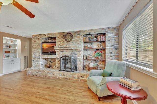 16426 Cavendish Dr, Houston, TX 77059 - living room with crown molding, ceiling fan, wood finished floors, built in shelves, and a brick fireplace