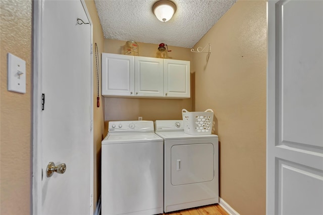 16426 Cavendish Dr, Houston, TX 77059 - washroom featuring cabinet space, washing machine and dryer, a textured ceiling, and light wood finished floors