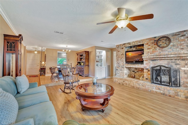 16426 Cavendish Dr, Houston, TX 77059 - living area featuring light wood finished floors, a ceiling fan, a textured ceiling, ornamental molding, and a fireplace