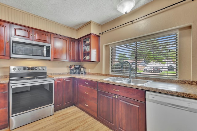 16426 Cavendish Dr, Houston, TX 77059 - kitchen with appliances with stainless steel finishes, dark brown cabinets, a textured ceiling, light wood-style flooring, and glass insert cabinets