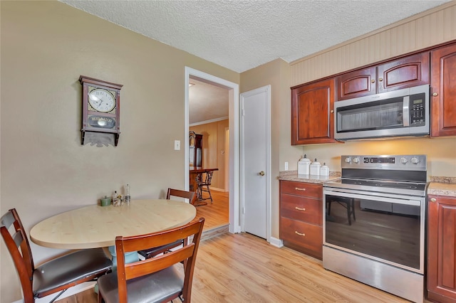 16426 Cavendish Dr, Houston, TX 77059 - kitchen featuring appliances with stainless steel finishes, light wood finished floors, and a textured ceiling