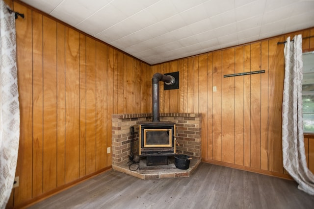 423 Pouland St, Zavalla, TX 75980 - unfurnished living room with wood finished floors, wood walls, and a wood stove