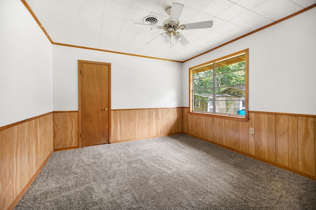 423 Pouland St, Zavalla, TX 75980 - spare room featuring ornamental molding, wooden walls, wainscoting, carpet flooring, and a ceiling fan