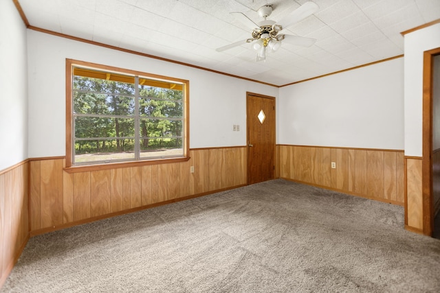 423 Pouland St, Zavalla, TX 75980 - carpeted empty room featuring a wainscoted wall, crown molding, wood walls, and a ceiling fan