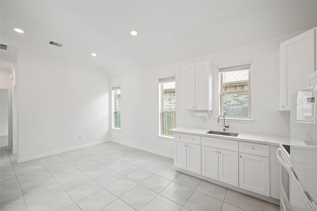 3447 Warwick River Trl, Kingwood, TX 77365 - kitchen with light countertops, white cabinetry, ornamental molding, light tile patterned floors, and recessed lighting