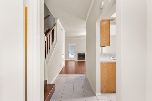 2910 Grants Lake Blvd Unit 1702, Sugar Land, TX 77479 - hallway with light tile patterned floors, stairway, crown molding, and a textured ceiling
