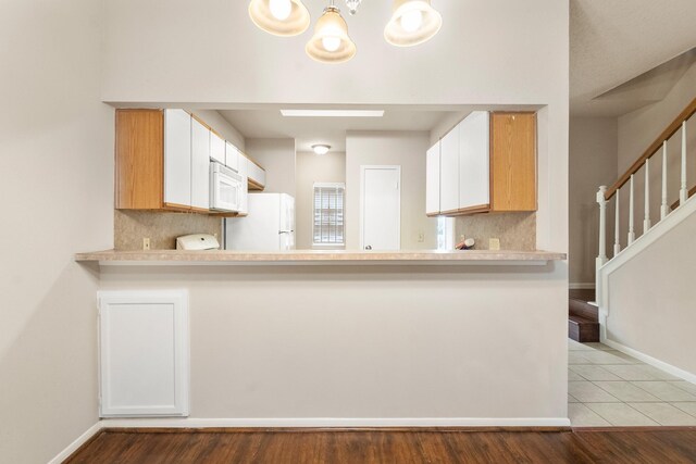 2910 Grants Lake Blvd Unit 1702, Sugar Land, TX 77479 - kitchen with white appliances, light countertops, backsplash, a chandelier, and a peninsula
