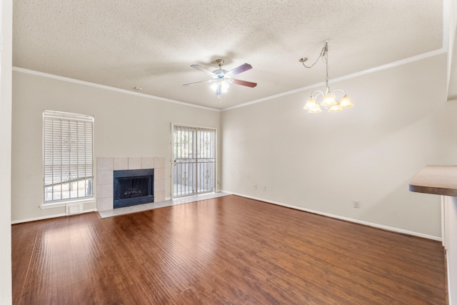 2910 Grants Lake Blvd Unit 1702, Sugar Land, TX 77479 - unfurnished living room featuring a ceiling fan, wood finished floors, a tile fireplace, a textured ceiling, and crown molding