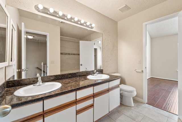 2910 Grants Lake Blvd Unit 1702, Sugar Land, TX 77479 - full bath with a textured ceiling, double vanity, tile patterned flooring, a shower, and a textured wall
