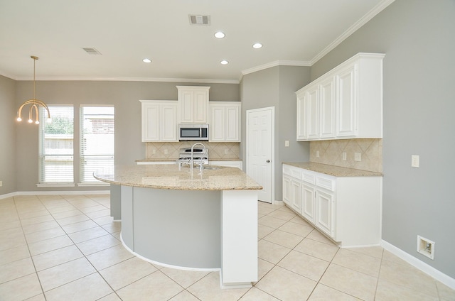 3910 Jade Cove Ln, Sugar Land, TX 77479 - kitchen featuring stainless steel microwave, light tile patterned floors, decorative backsplash, light stone countertops, and white cabinets