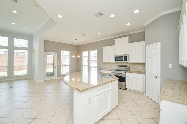 3910 Jade Cove Ln, Sugar Land, TX 77479 - kitchen featuring appliances with stainless steel finishes, crown molding, light tile patterned floors, tasteful backsplash, and a kitchen island with sink