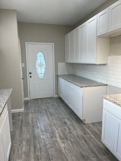 1012 Rd 5606, Cleveland, TX 77327 - kitchen featuring light stone countertops, tasteful backsplash, dark wood-type flooring, and white cabinetry