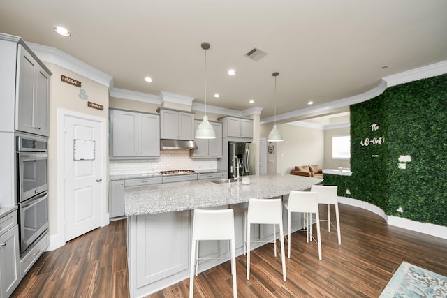 31201 Redwood Manor Ct, Spring, TX 77386 - kitchen with gray cabinets, appliances with stainless steel finishes, ornamental molding, under cabinet range hood, and dark wood-type flooring