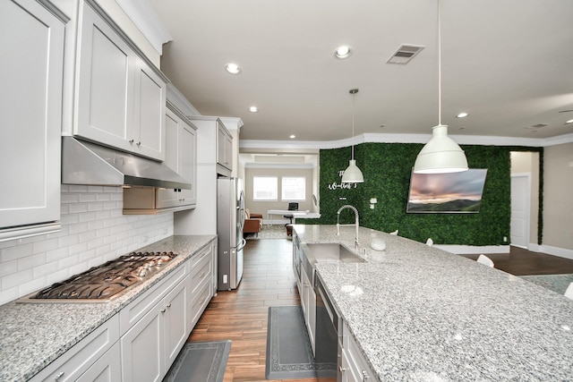 31201 Redwood Manor Ct, Spring, TX 77386 - kitchen featuring appliances with stainless steel finishes, under cabinet range hood, tasteful backsplash, crown molding, and dark wood finished floors