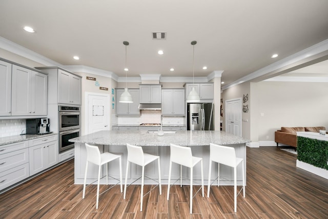 31201 Redwood Manor Ct, Spring, TX 77386 - kitchen with appliances with stainless steel finishes, under cabinet range hood, gray cabinetry, decorative backsplash, and crown molding