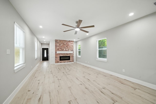 335 Todd St, Tomball, TX 77375 - unfurnished living room with ceiling fan, recessed lighting, light wood-type flooring, and a fireplace