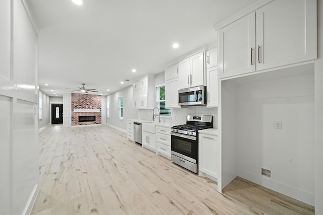 335 Todd St, Tomball, TX 77375 - kitchen with appliances with stainless steel finishes, ceiling fan, white cabinetry, light wood-type flooring, and recessed lighting