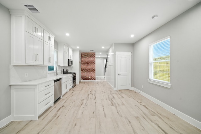 335 Todd St, Tomball, TX 77375 - kitchen with appliances with stainless steel finishes, light countertops, light wood-type flooring, white cabinets, and recessed lighting