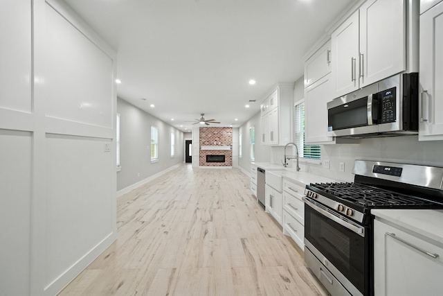 335 Todd St, Tomball, TX 77375 - kitchen with appliances with stainless steel finishes, light wood-style floors, recessed lighting, white cabinets, and ceiling fan