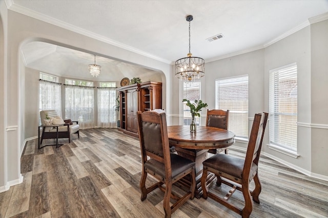 17227 Horsetooth Canyon Dr, Houston, TX 77095 - dining room featuring arched walkways, a chandelier, wood finished floors, and crown molding