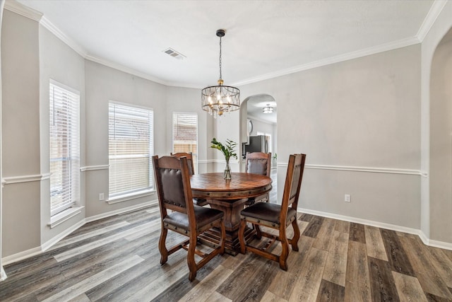 17227 Horsetooth Canyon Dr, Houston, TX 77095 - dining space featuring arched walkways, wood finished floors, a chandelier, and crown molding