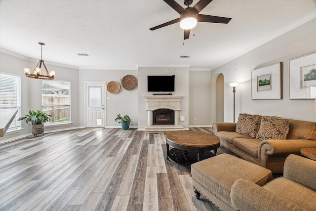 17227 Horsetooth Canyon Dr, Houston, TX 77095 - living area with wood finished floors, arched walkways, a fireplace with raised hearth, a ceiling fan, and a chandelier