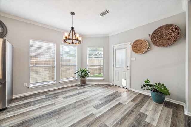 17227 Horsetooth Canyon Dr, Houston, TX 77095 - unfurnished dining area with a chandelier, wood finished floors, and crown molding