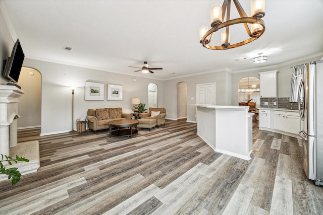 17227 Horsetooth Canyon Dr, Houston, TX 77095 - living room featuring arched walkways, a chandelier, ceiling fan, ornamental molding, and light wood finished floors