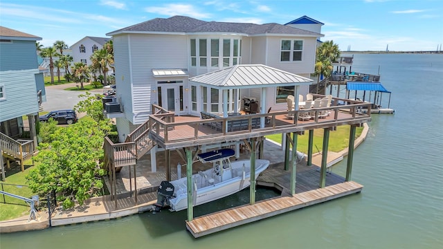 1303 Outrigger, Tiki Island, TX 77554 - back of property with stairway, a deck with water view, french doors, a metal roof, and a standing seam roof
