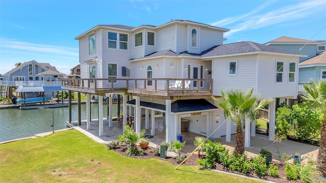 1303 Outrigger, Tiki Island, TX 77554 - rear view of house featuring a lawn, a shingled roof, a deck with water view, and a residential view