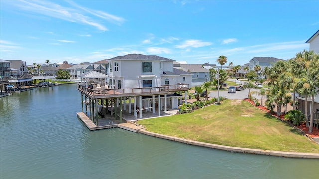 1303 Outrigger, Tiki Island, TX 77554 - back of house featuring a residential view, a lawn, and a deck with water view
