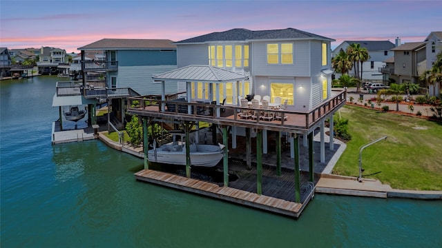 1303 Outrigger, Tiki Island, TX 77554 - back of property with a water view, boat lift, a lawn, and a residential view