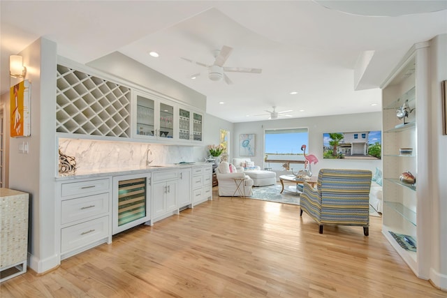 1303 Outrigger, Tiki Island, TX 77554 - indoor bar with wine cooler, light wood-style floors, tasteful backsplash, ceiling fan, and recessed lighting