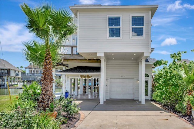 1303 Outrigger, Tiki Island, TX 77554 - view of front facade featuring a garage and concrete driveway