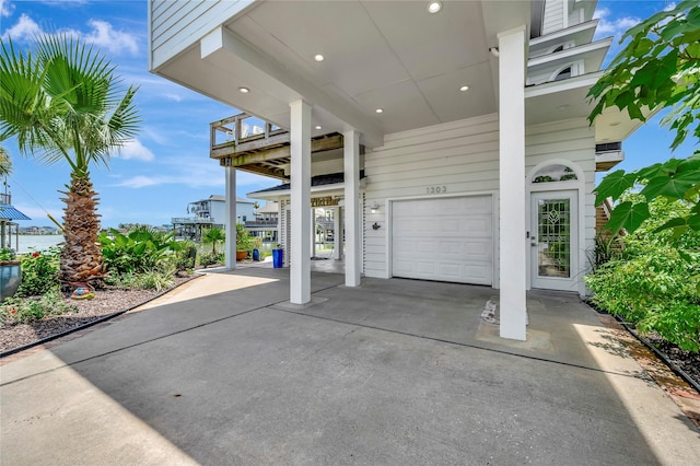 1303 Outrigger, Tiki Island, TX 77554 - view of patio featuring an attached garage and driveway