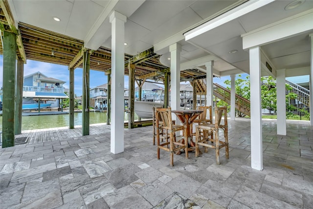 1303 Outrigger, Tiki Island, TX 77554 - view of patio / terrace featuring stairs and a water view