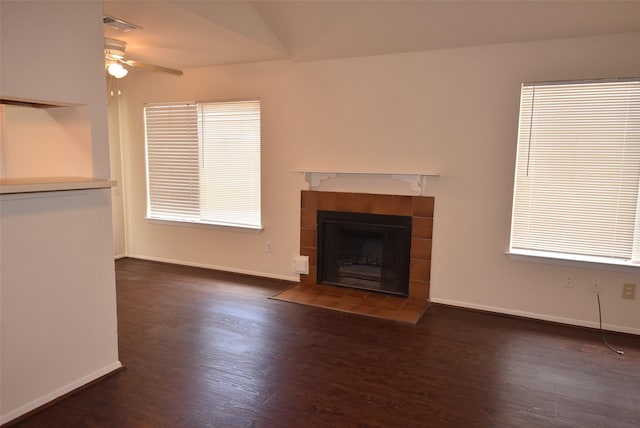 16702 Vista Oak Dr, Houston, TX 77073 - unfurnished living room featuring ceiling fan, wood finished floors, a tiled fireplace, and healthy amount of natural light