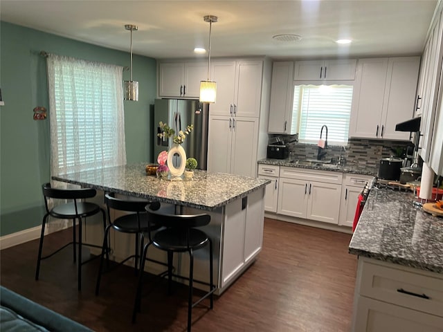 8823 Shadow Crest St, Houston, TX 77074 - kitchen with freestanding refrigerator, a kitchen breakfast bar, dark stone countertops, tasteful backsplash, and recessed lighting